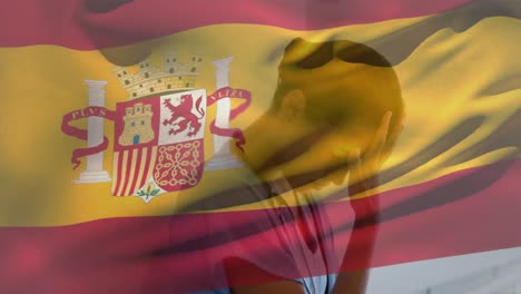 digital composition of spain flag waving against stressed caucasian female health worker at hospital