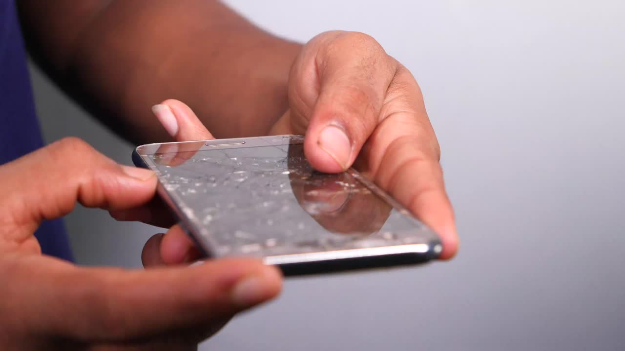 Person holding a cracked smartphone