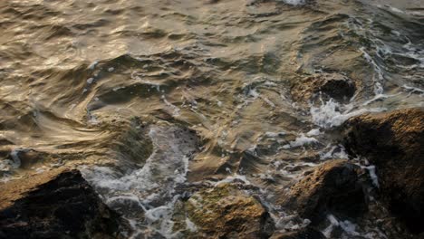 waves crashing on rocks at sunset