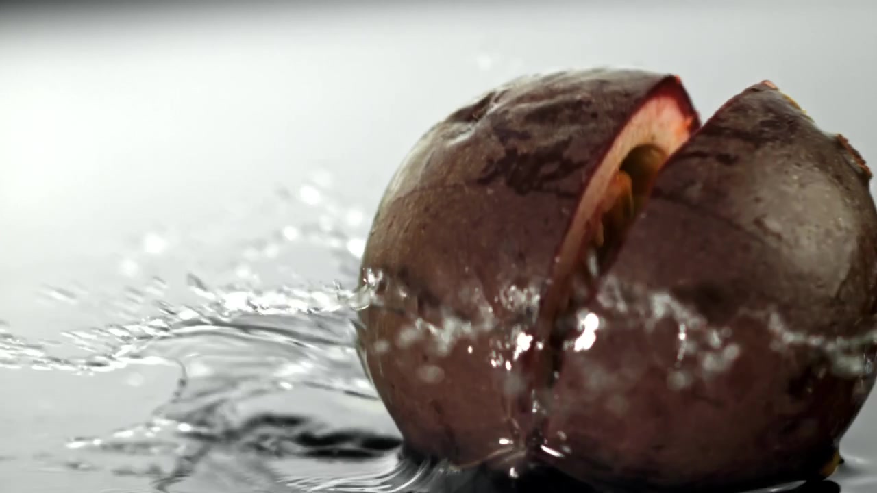 Frutto della passione fresco che si spacca al rallentatore mentre cade nell'acqua