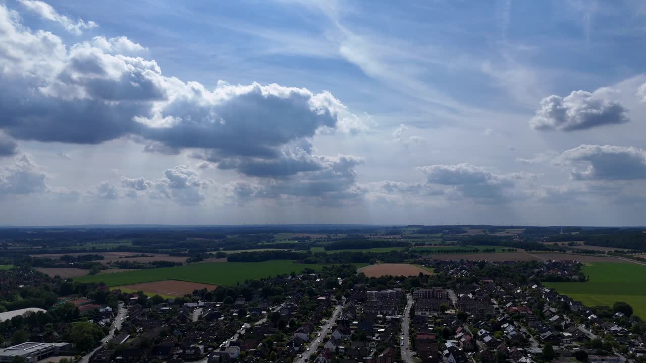 Houses and homes of small american town. Clouds at sky. Sunny day in summer. Aerial lateral wide shot. Rural countrside farmland in USA. Quiet suburb district