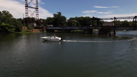 a motorboat is coming in to dock at the boat launch on the saugatuck river in ct on a sunny day