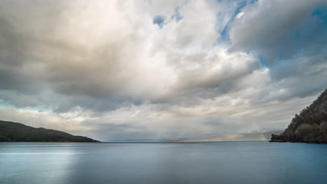 inverted god rays piercing through the thick clouds above the fjord