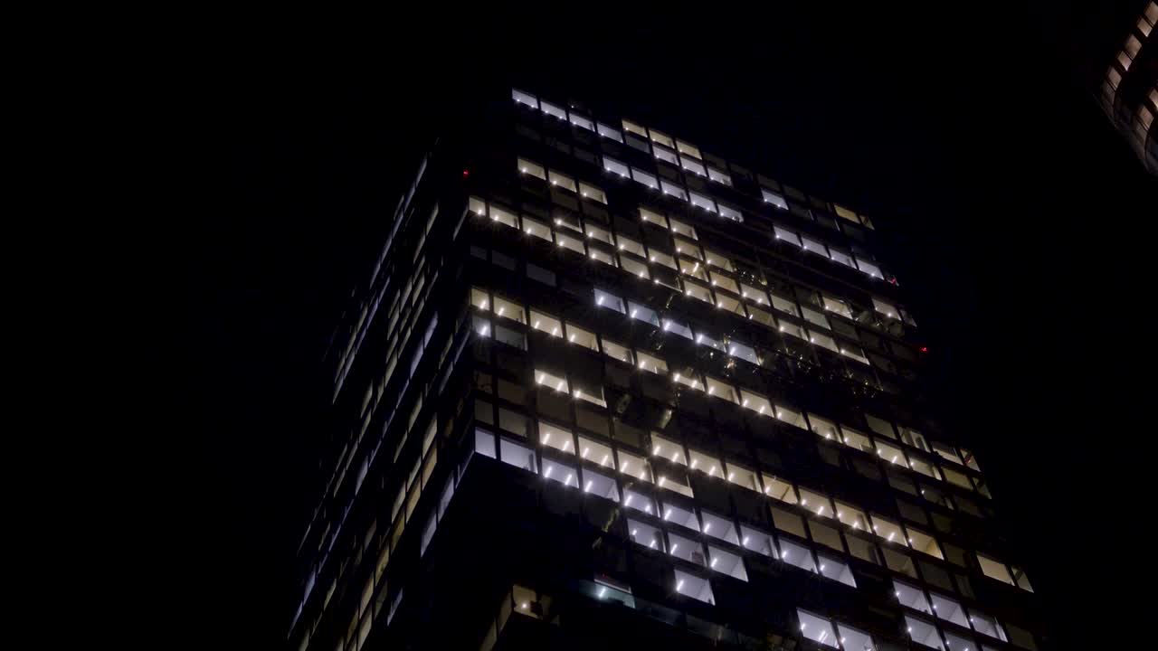 Illuminated skyscraper in Frankfurt, Germany at night, with glowing office windows