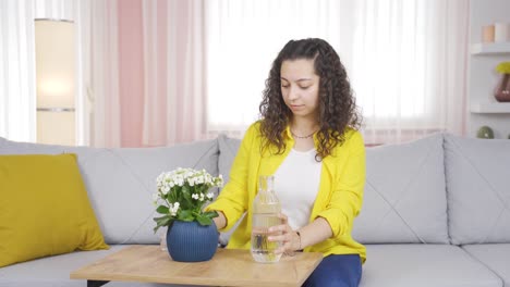 Young-woman-watering-flowers-at-home.-He-is-happy-and-enjoying.