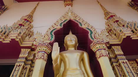 golden buddha statue at the wat plai laem temple in koh samui zoom close up shot