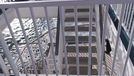 ferry or boat ride, ship staircase and water waves with sun reflections and feet of a passenger