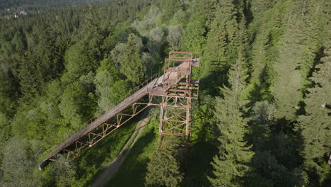 view of old rusted ski jump surrounded by dense forest in bakuriani, georgia