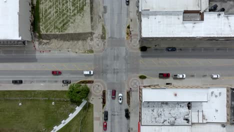 Intersection-in-downtown-Marshalltown,-Iowa-with-traffic-moving-and-drone-video-overhead-stable