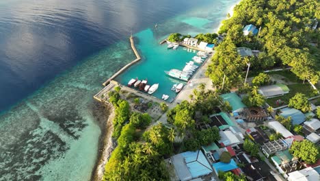 Luftaufnahmen-Einer-Drohne,-Die-Bei-Sonnenaufgang-über-Der-Insel-Thinadhoo-In-Richtung-Hafen-Fliegt