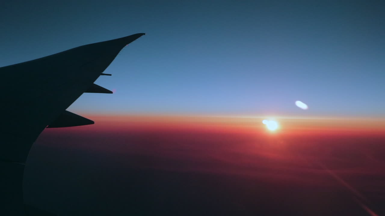 amanecer temprano en la mañana sobre el ala de un gran avión de pasajeros en un cielo azul cristalino