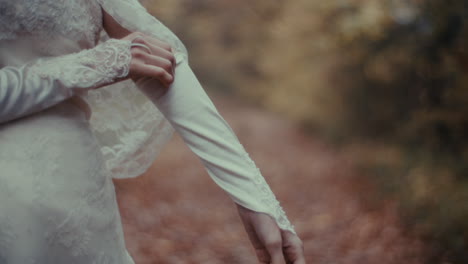 close-up of bride's hands in lace gloves and wedding dress