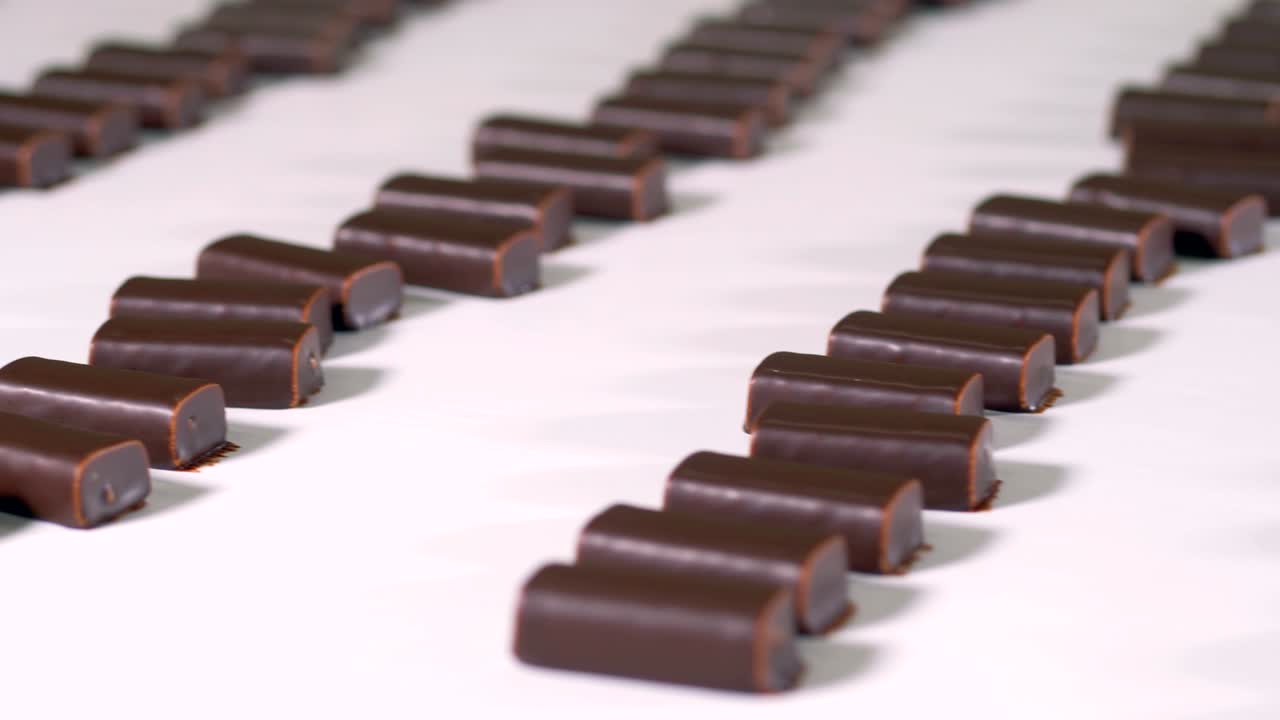 los dulces de chocolate preparados se mueven a lo largo de la línea de producción en la fábrica de dulces.