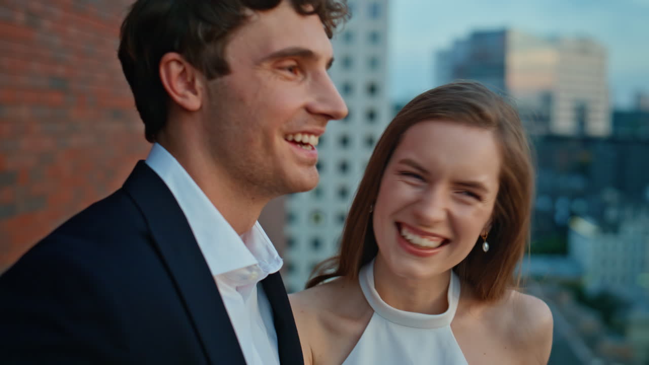 Dating couple standing rooftop at evening closeup. Romantic soulmates laughing