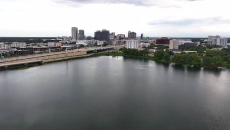 Rising-drone-wide-shot-of-traffic-on-highway-overpasses-Downtown-of-Orlando-City,-USA