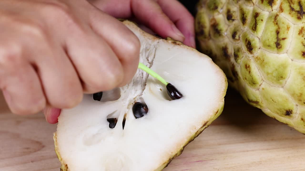 손은 칼로 크레스트 사과를 잘라내고 있습니다.