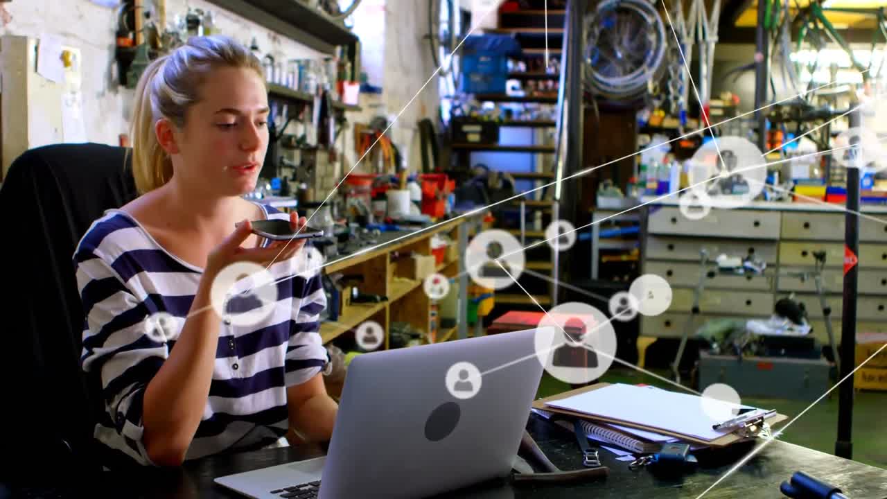 animación de la red de conexiones sobre una mujer caucásica feliz usando un teléfono inteligente y una computadora portátil