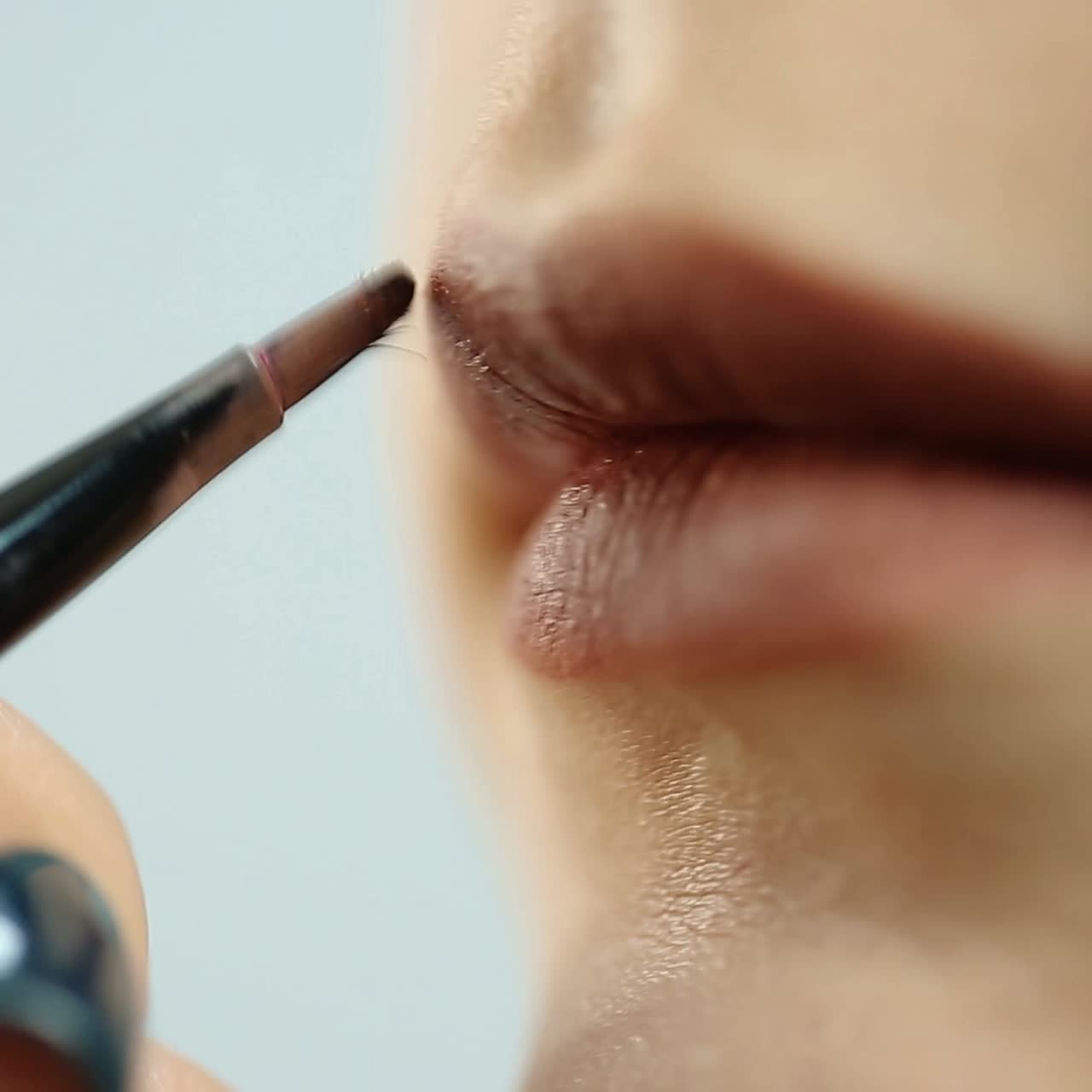 una chica se pinta los labios.