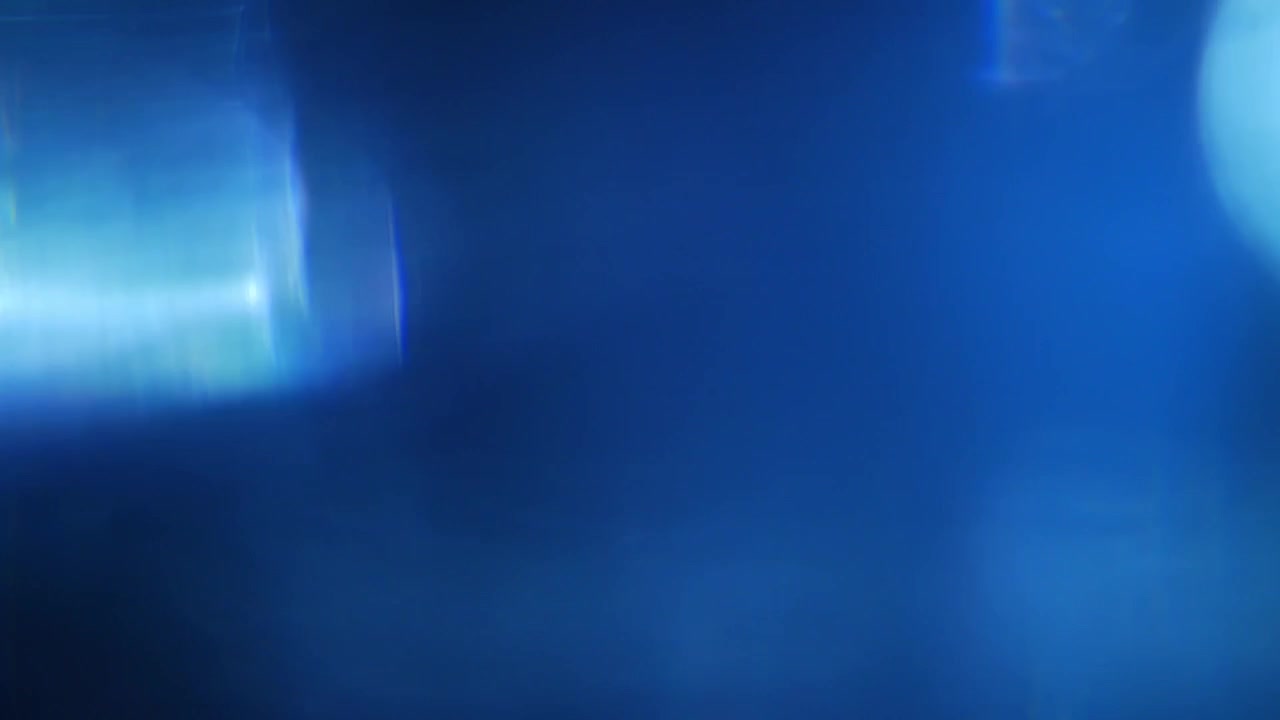 Fughe di luce blu dinamiche e bagliori dell'obiettivo su sfondo nero