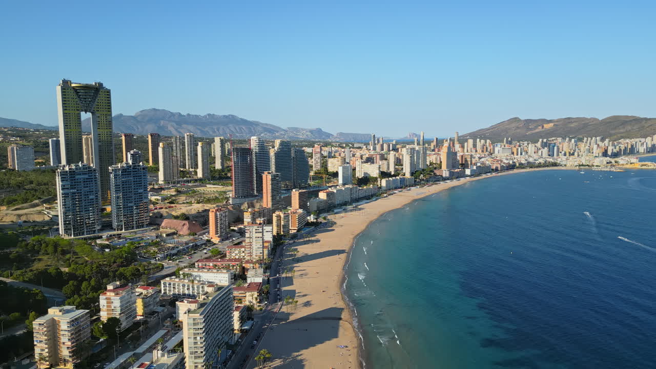 Aerial drone view of the buildings along the coastline and the sea in Benidorm, Spain in daylight
