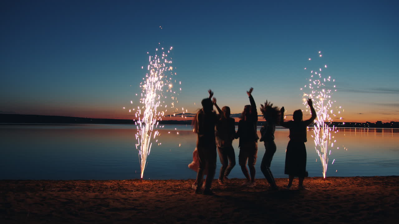 Friends Celebrating at Sunset Beach with Fireworks