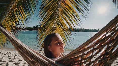 girl relaxing in a hammock on a tropical beach