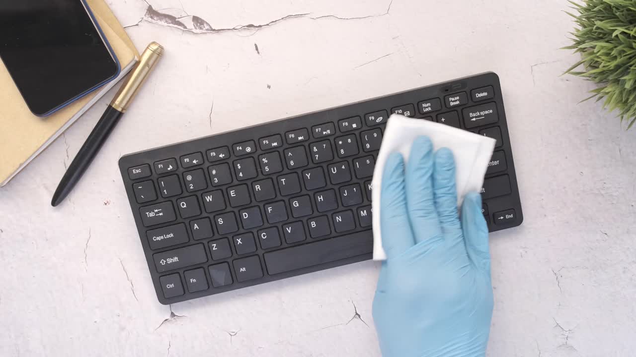 limpieza de un teclado con guantes