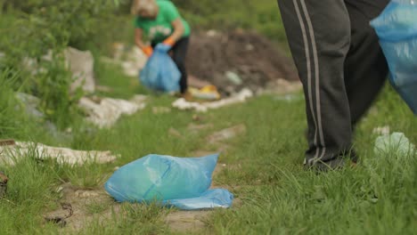 volunteer team cleaning up dirty park from plastic bags, bottles. reduce trash cellophane pollution