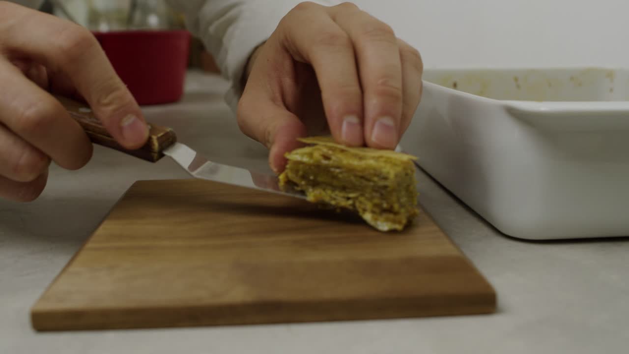 el chef coloca piezas de baklava en un plato decorativo de madera
