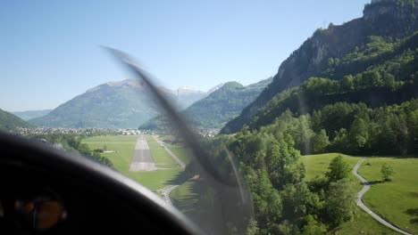 aerial view of abandoned airport between mountains, small private plane landing on runway