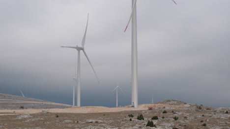 a large wind turbine plant. sustainable and renewable green energy from the wind. turbines arranged on a mountain plateau. windy weather before the storm.