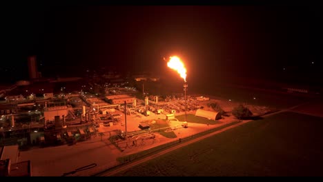 the radiant light from gas flaring brightens the nearby surroundings - aerial drone shot