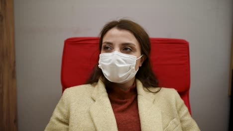 Beautiful-woman-wearing-protective-disposable-medical-mask-and-fashionable-clothes-rest-a-rocking-chair