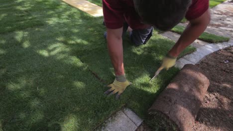 Un-Trabajador-Corta-El-Césped-Del-Rollo-Con-Un-Cuchillo