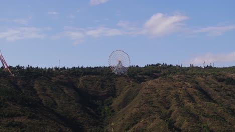 high aerial shot above ferris wheel at mtatsminda park in tbilisi, georgia