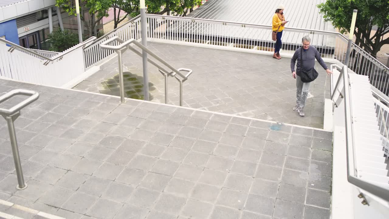 Entering overpass, man climbing stairs checking smartphone directions as woman using smartphone