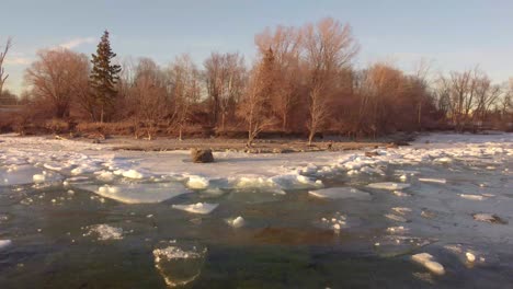 young-women-wearing-pride-colors-jacket-on-a-Rock-in-the-middle-of-a-frozen-lake