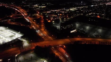 an aerial view over illuminated roads with an orange glow at night