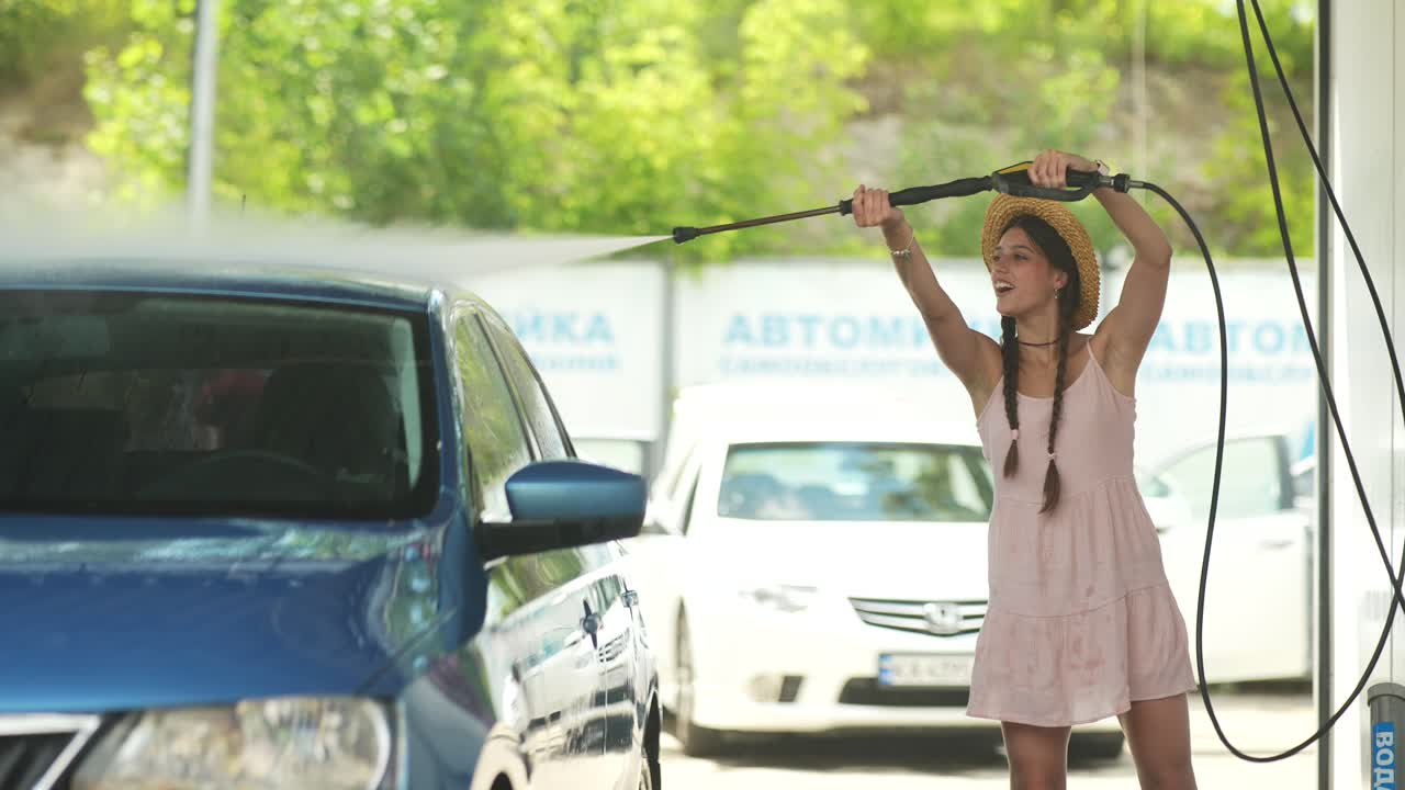 mujer lavando automóviles en un lavado de automóviles de autoservicio