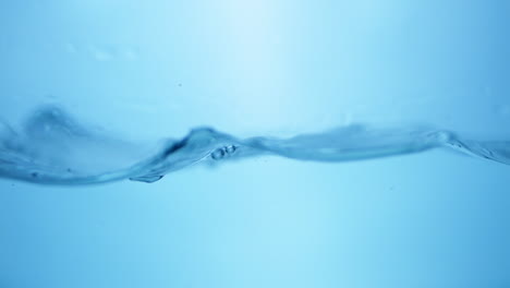 Makroansicht-Der-Strömungsdynamik-Von-Süßwassertropfen-In-Bewegung,-Symphonie-Der-Natur,-Zeitlupen-Wasserkräuseleffekt-In-Blauem-Farbton