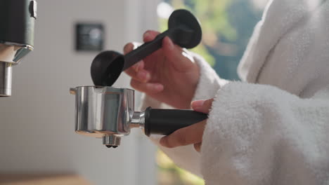 woman adds coffee powder to portafilter. lady fills container with espresso powder preparing strong drink to boost energy. hot beverage for start of day