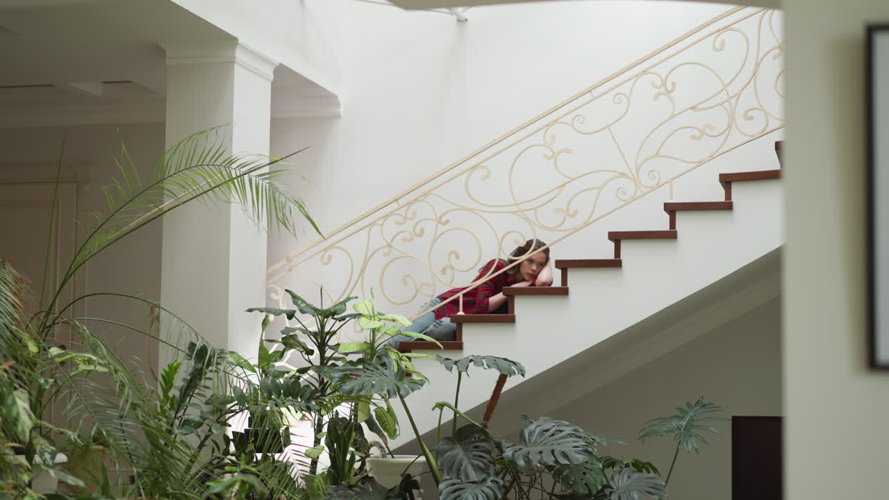 женщина выражает меланхолию, лежа на лестнице. дама с проблемами психического здоровья имеет приступ дома. сломанная женщина нуждается в психологическом лечении