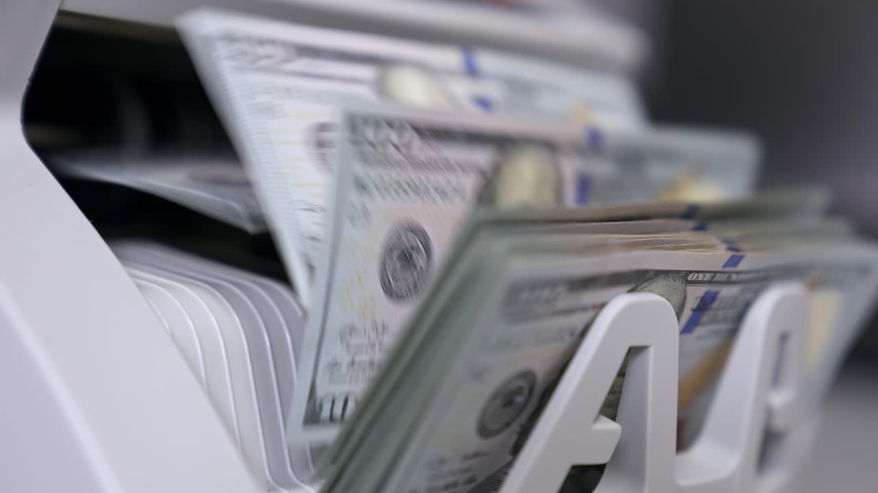 Money counting machine. Banknote counter are counting hundred dollar bills. Close-up