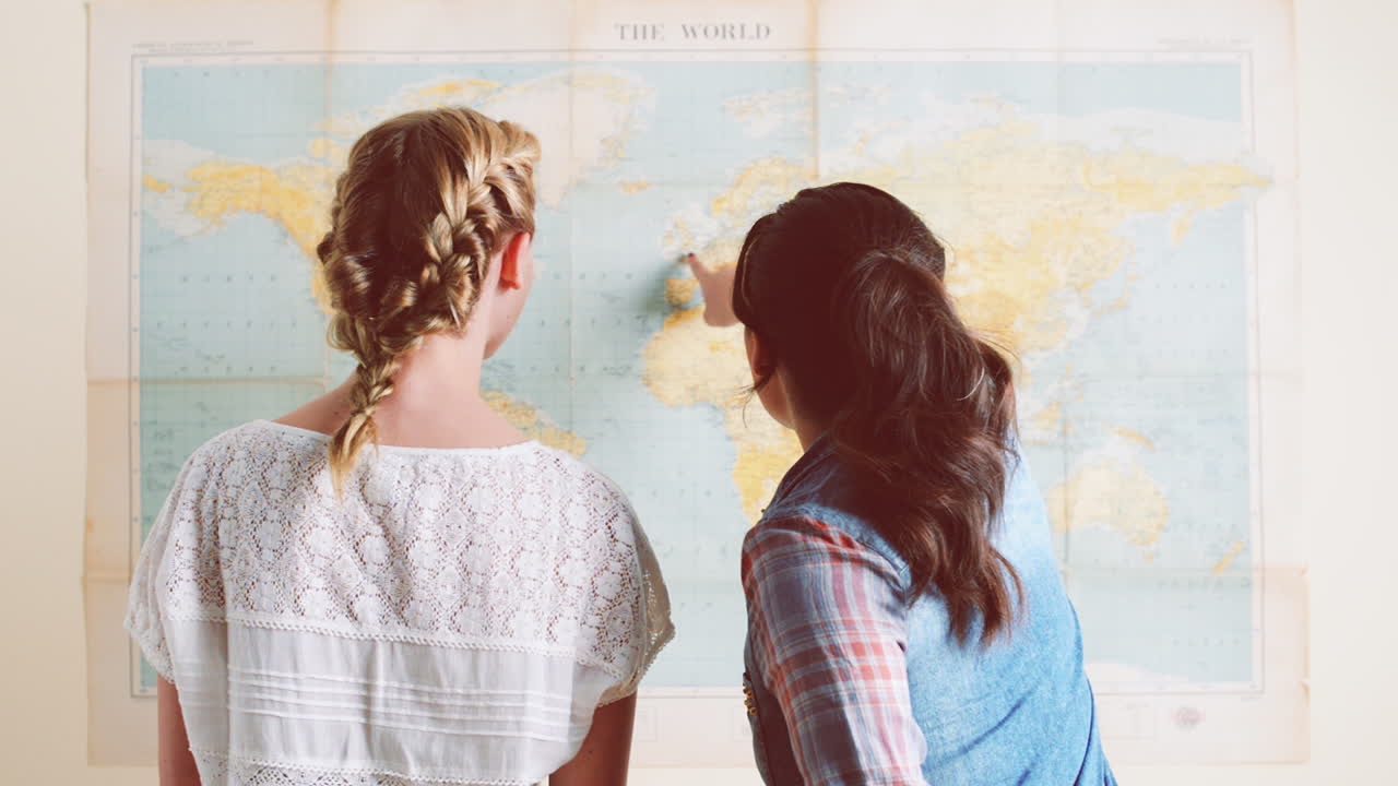 ragazze turistiche che guardano la mappa del mondo pianificano avventure di viaggio