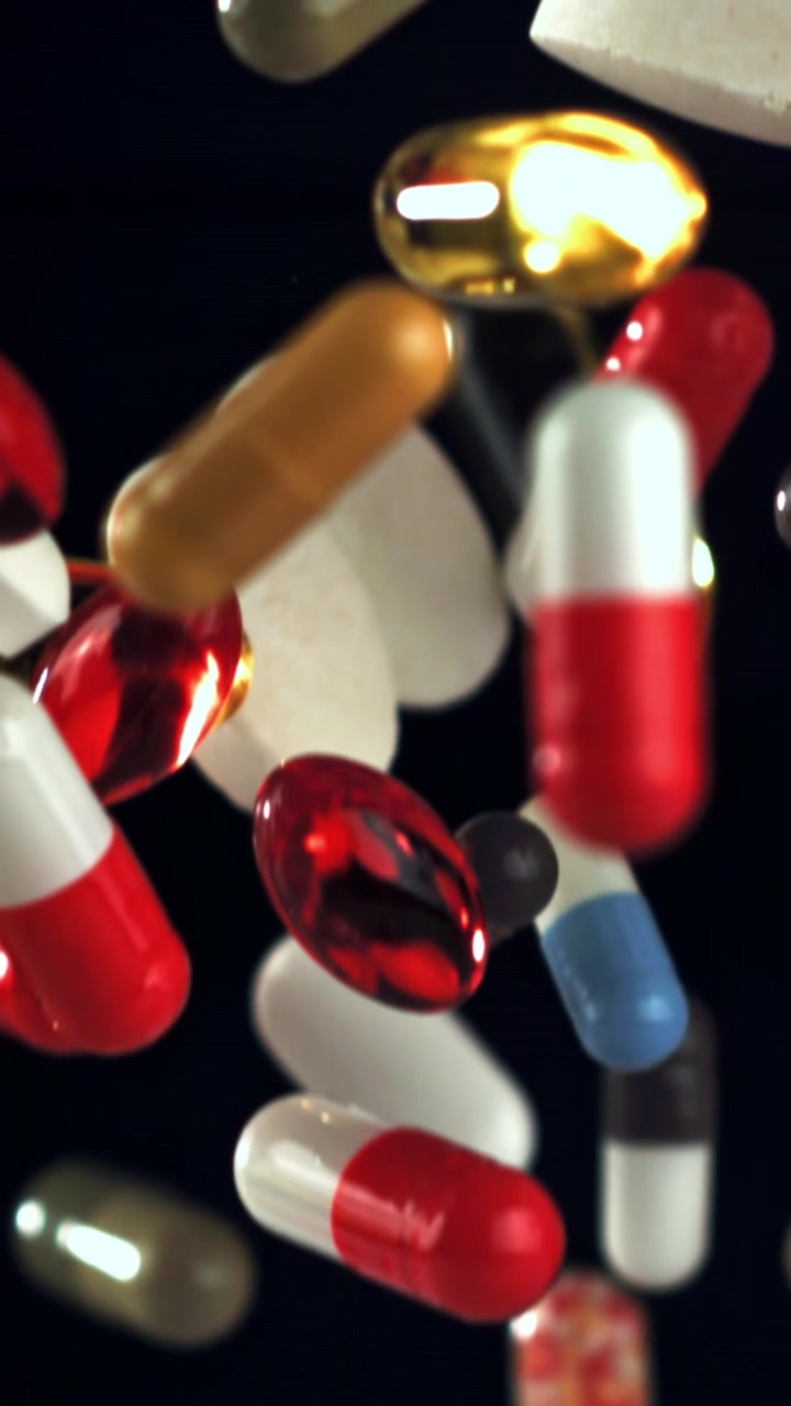 Pillole e capsule colorate che cadono al rallentatore