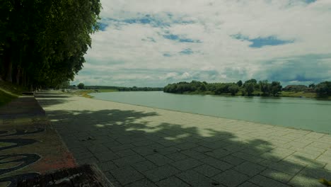 empty and desolate promenade by river's edge on bright sunny day, covid-19 pandemic, static