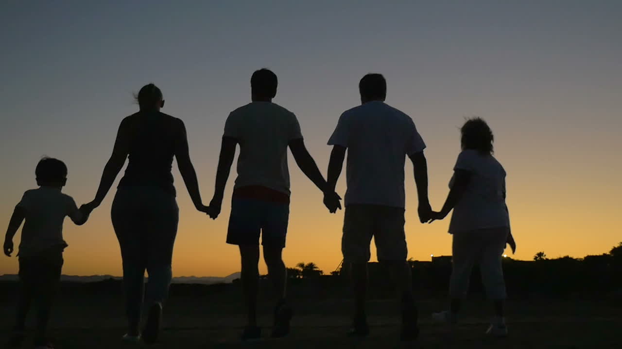 해가 지는 동안 야외에서 산책하는 큰 친절한 가족