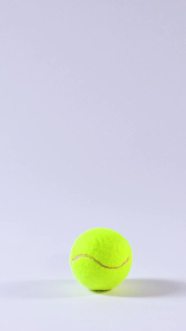Tennis ball rolling across a smooth surface