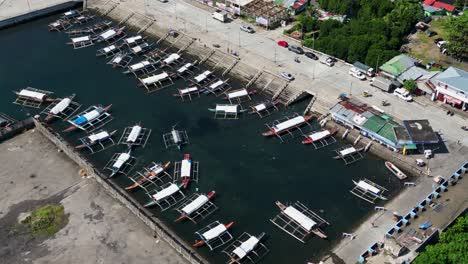 docked outrigger boats at tabaco port in tabaco city, bicol, philippines. aerial drone shot