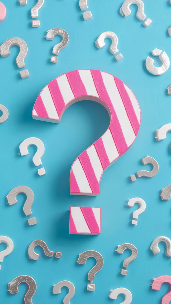 Vertical video: Remaining striped pink question mark on blue mat, flanked by silver question marks